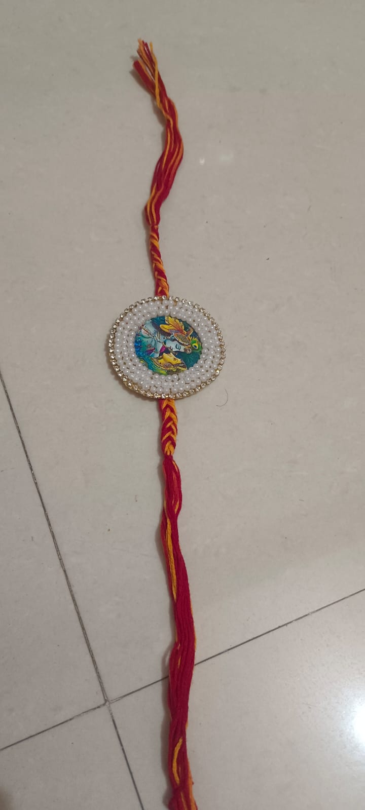 Radha Krishna design rakhi with traditional thread for Raksha Bandhan