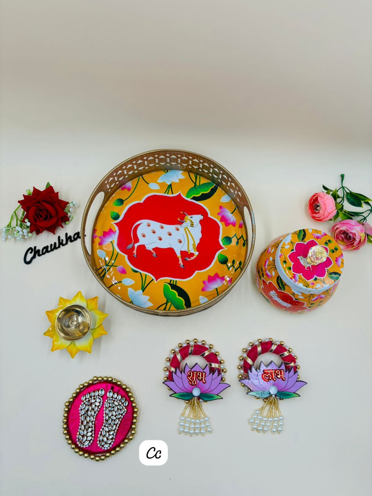 Pichwai gift items including decorative trays, dry fruit jars, flower diyas and Shubh Labh sets