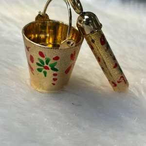 Decorative golden balti with pichkari for Krishna Holi celebration mandir decoration