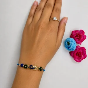 Designer peacock rakhi with blue and green stones for Raksha Bandhan
