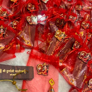 Premium Durga Chalisa and traditional pooja bell packed in decorative potli bag for Navratri gifting and religious return gifts.
